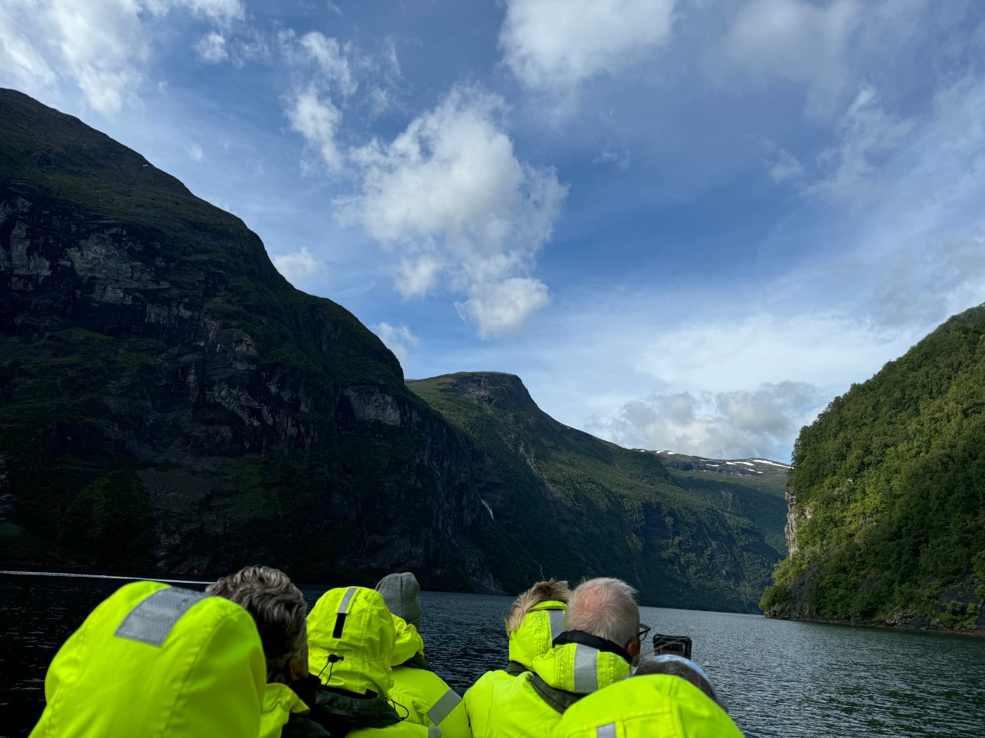 Guests on a RIB boat safari below the cliffs of Geirangerfjord