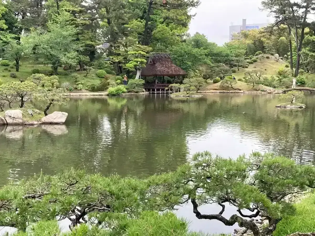 Thatched teahouse and pond at Shukkei-en garden in Hiroshima
