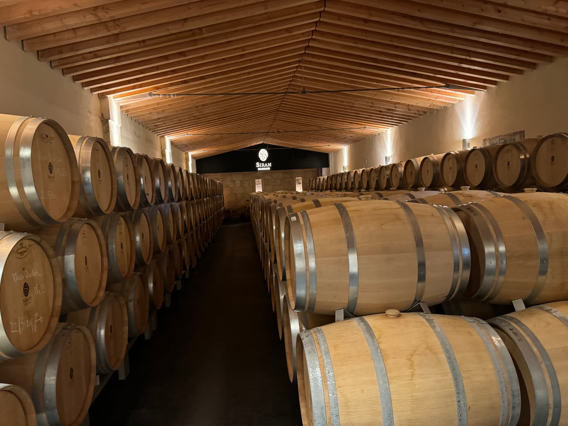 Oak barrels aging in a Margaux château cellar