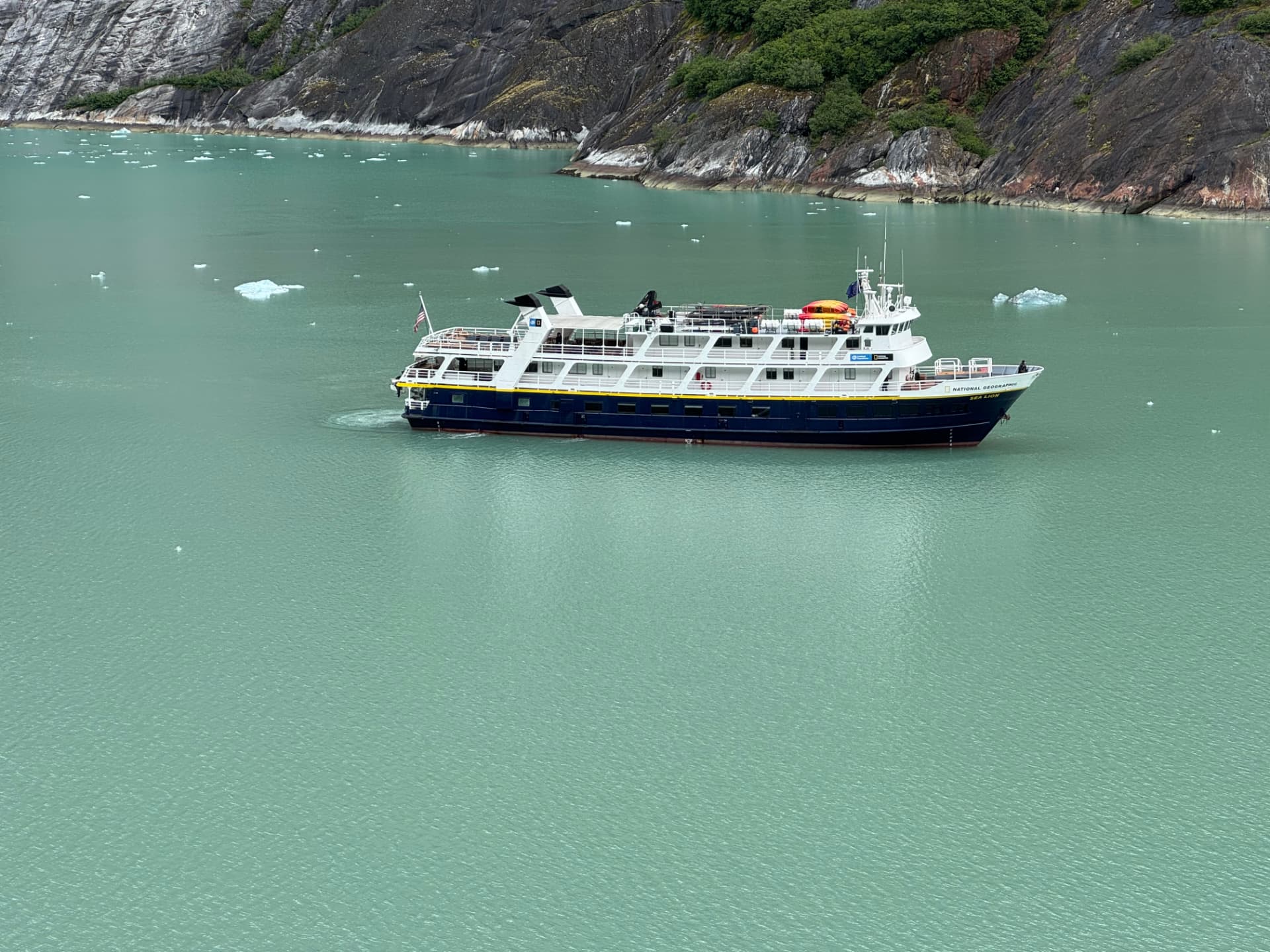 National Geographic Quest sailing through an ice-dotted Alaskan fjord