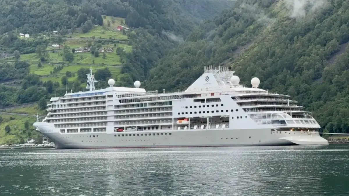 Silversea Silver Dawn framed by a green fjord