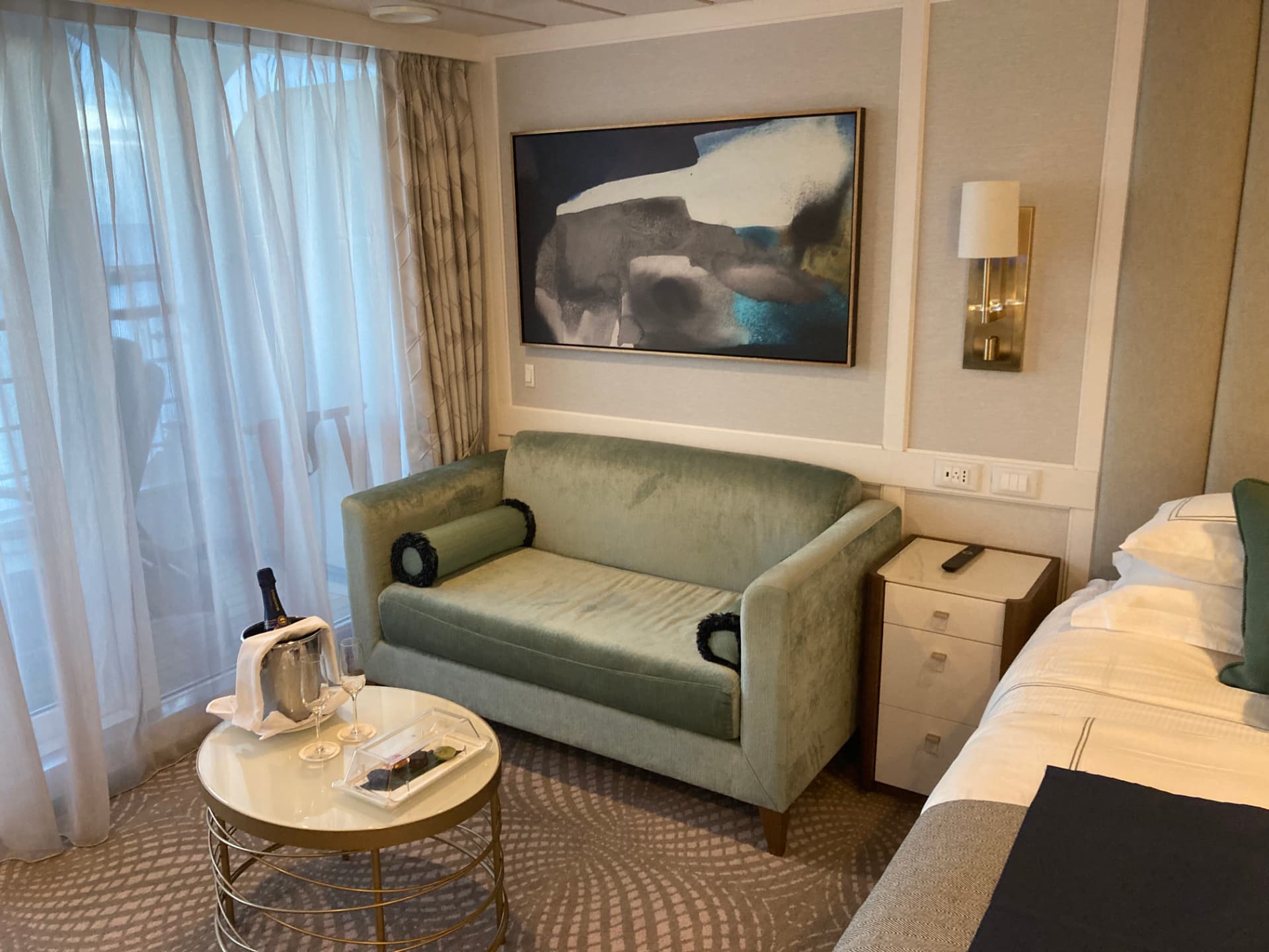 Penthouse suite sitting area aboard Oceania Sirena with champagne and canapes on arrival