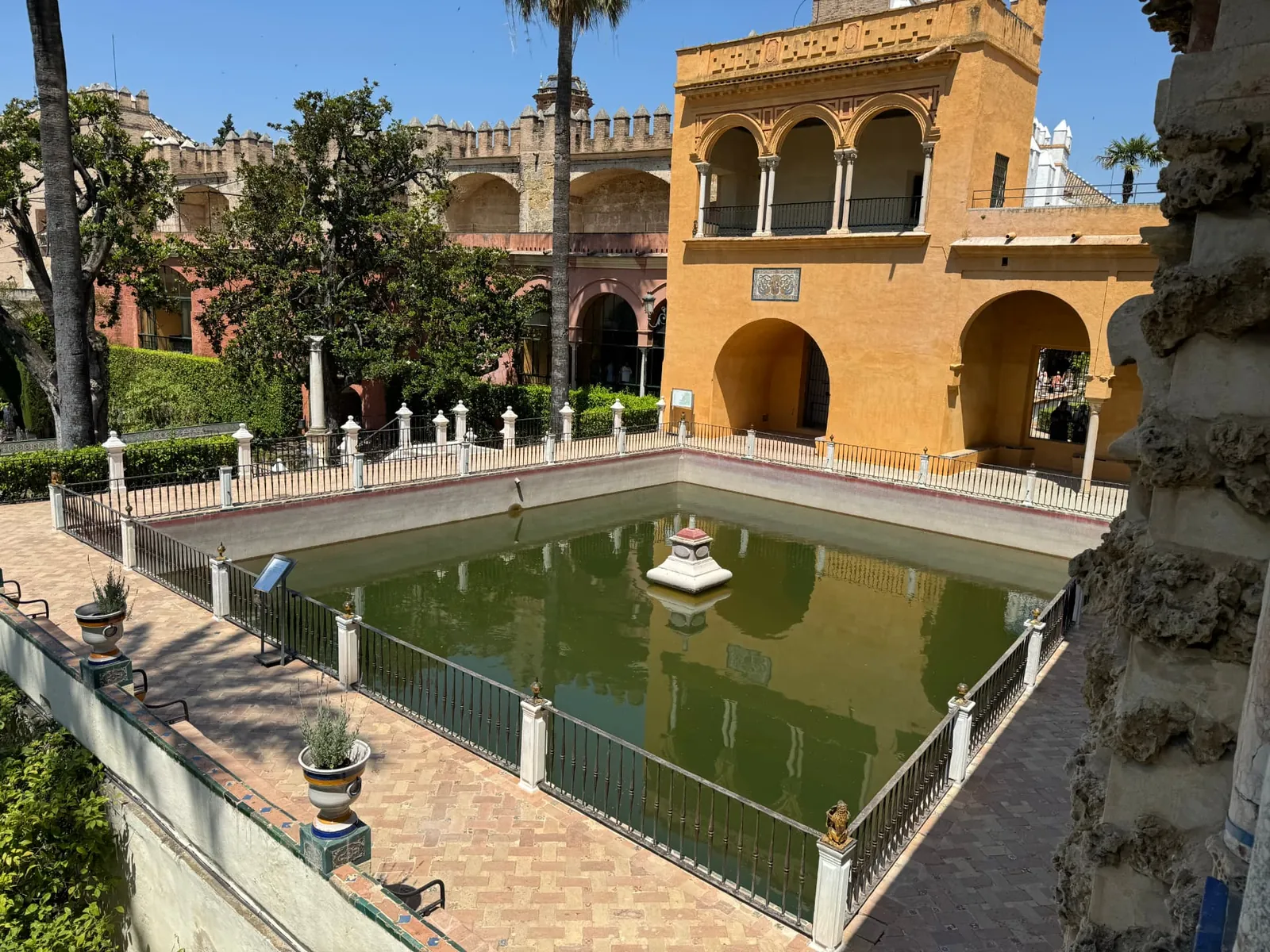 Palms and arcades around a pool in the Alcázar gardens