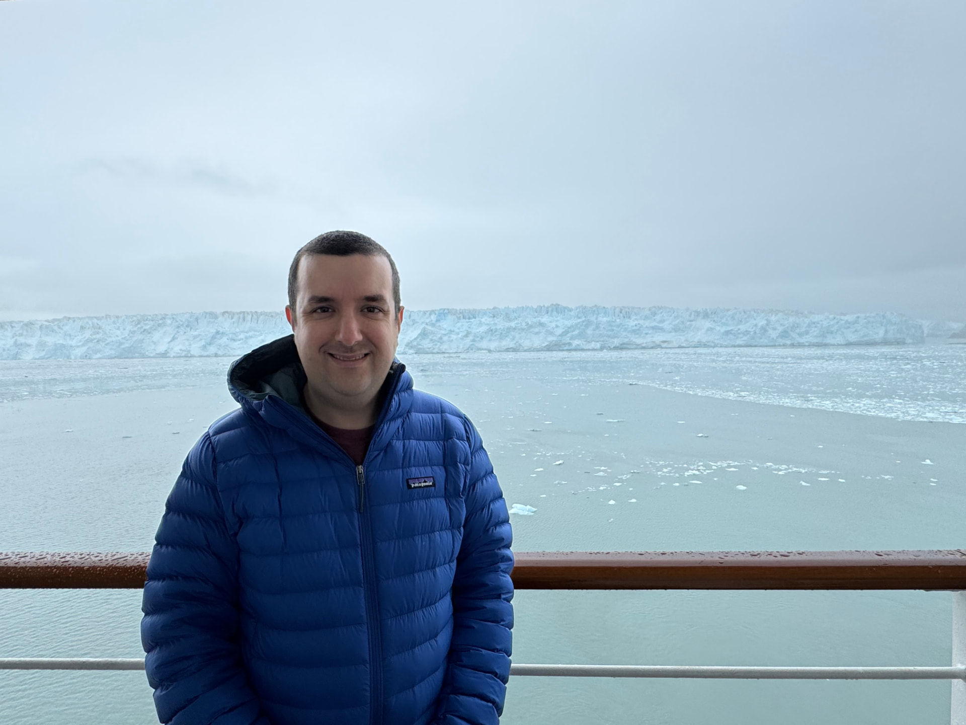 Ben with a tidewater glacier and ice floes in the background in Alaska