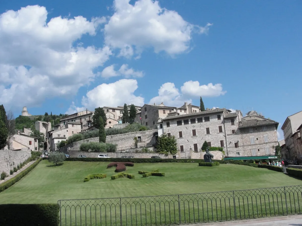 A Tuscan hill town of pale stone above a green lawn