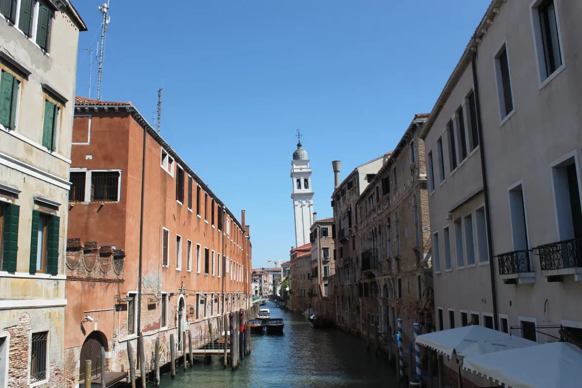 A quiet Venetian side canal beneath a bell tower
