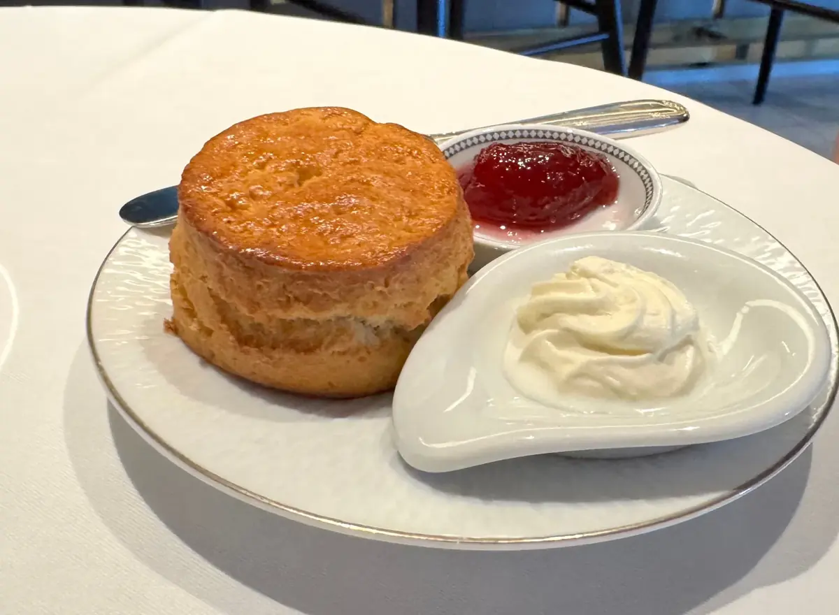 Warm scone with strawberry jam and clotted cream at afternoon tea on Regent Seven Seas