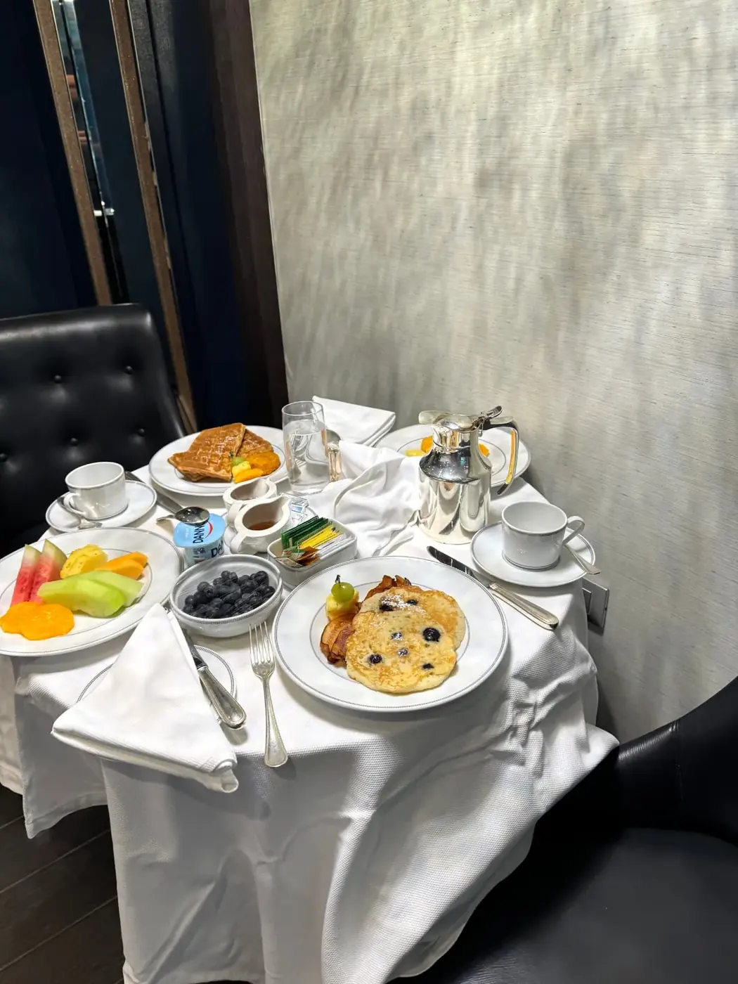 Room service breakfast in a Regent Penthouse suite with blueberry pancakes, waffles, fruit and coffee