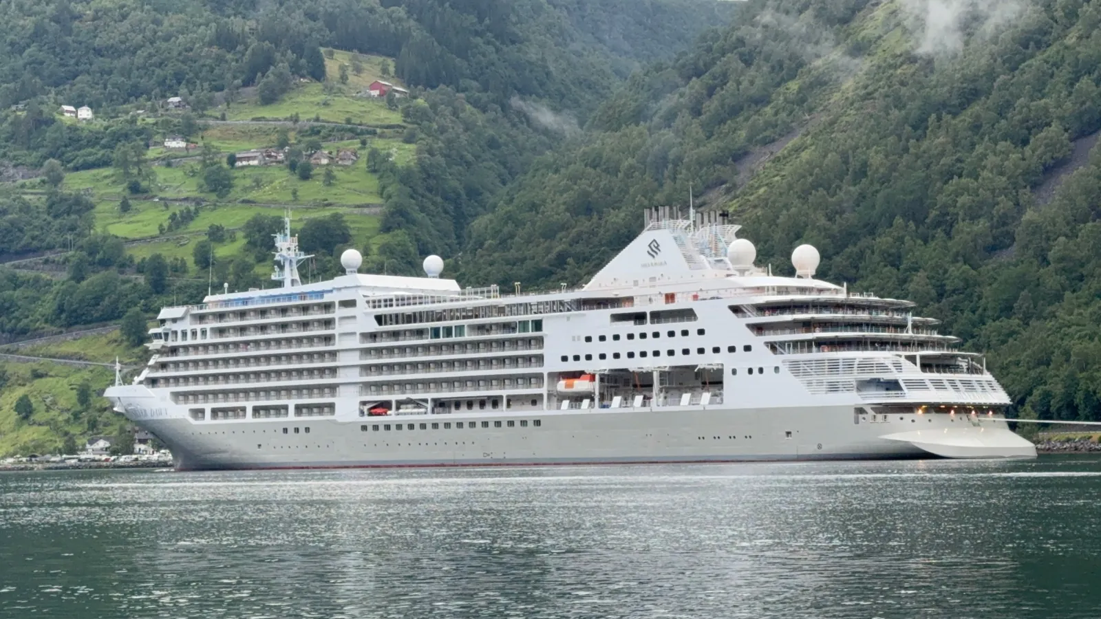 Silversea Silver Dawn framed by a green fjord