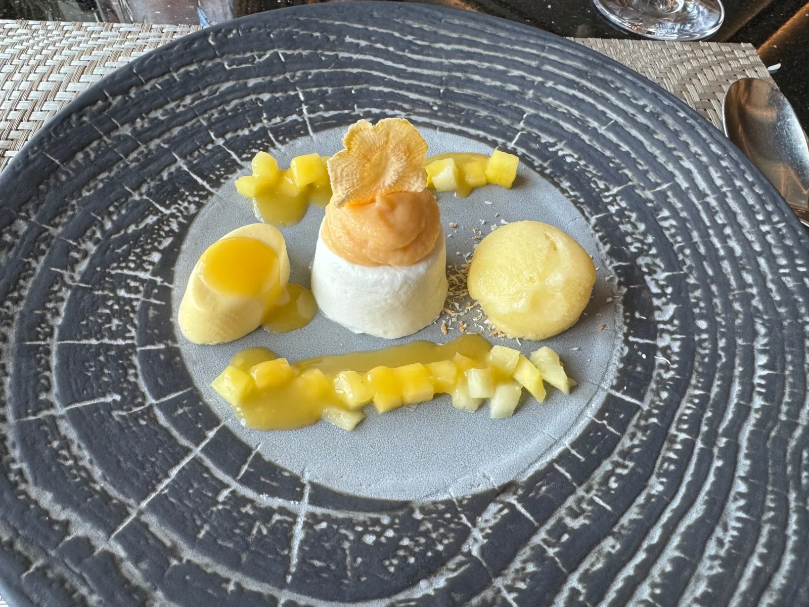 Coconut parfait with mango sorbet and tropical fruit on a textured Silversea plate