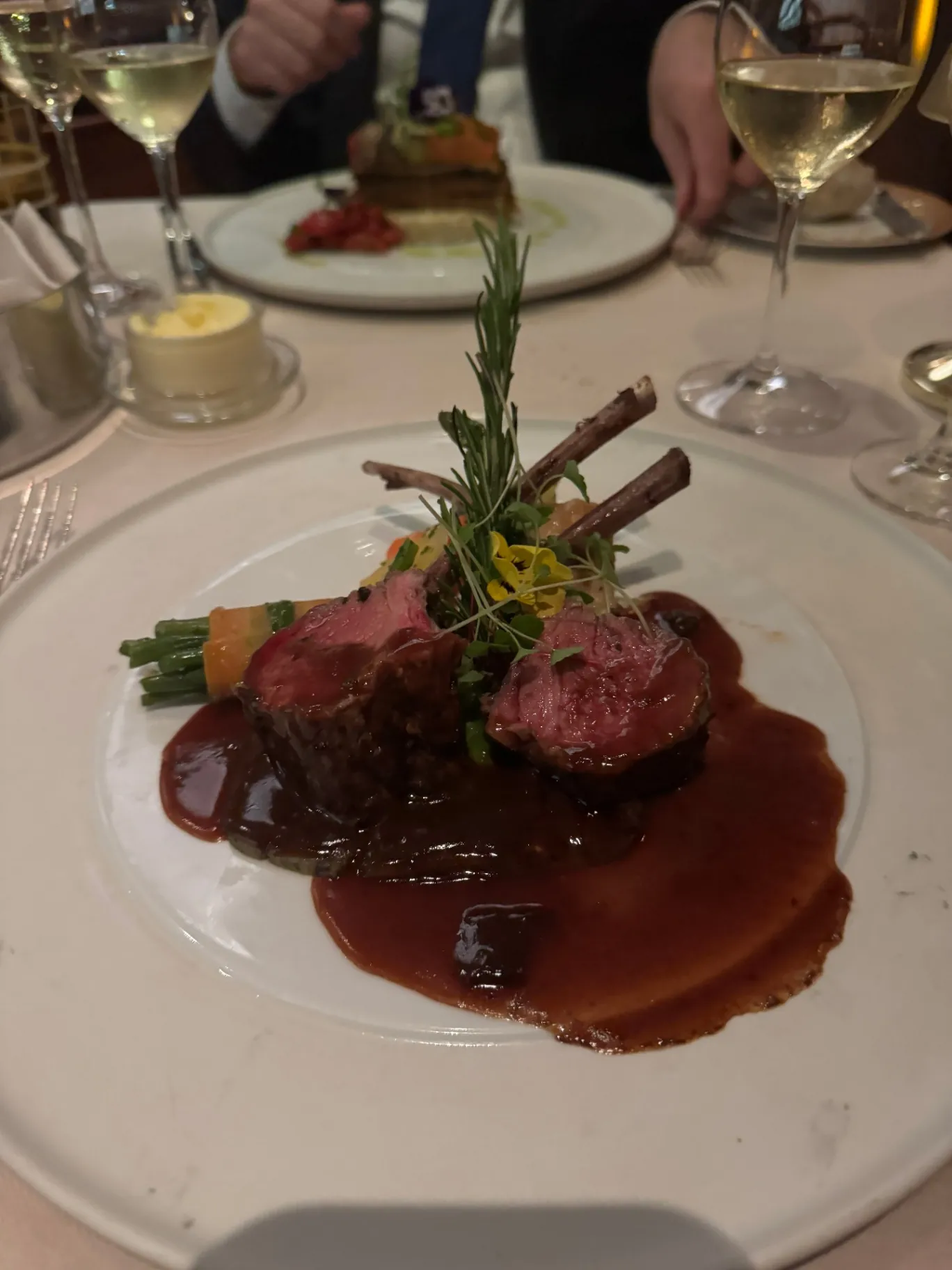 Rack of lamb with red wine jus and pressed vegetables in a Silversea dining room